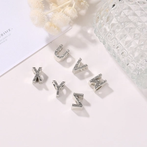 Detalle de cuentas de letras U-Z en plata vintage con textura granulada para joyería DIY