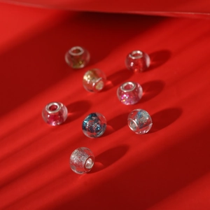 Close-up of colorful large hole glass beads with silver metal core and silver glitter