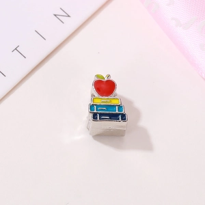 Creative stack of books and red apple bead charm made of colorful enamel and metal