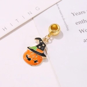 Macro detail of Halloween pumpkin witch hat charm with polished enamel and gold plating