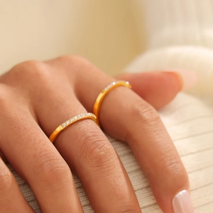 Set aus zwei minimalistischen vergoldeten Titanstahlringen mit Pavé-Zirkonia auf einem Finger