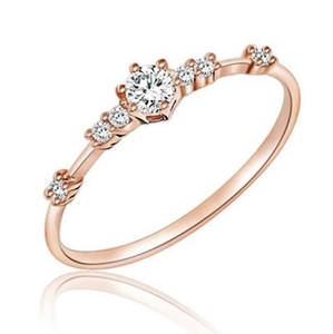 Close-up of elegant rose gold ring featuring seven sparkling round cut white stones
