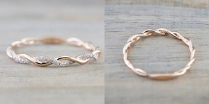Macro shot of rose gold twist rings with micro-pave crystals on wooden background