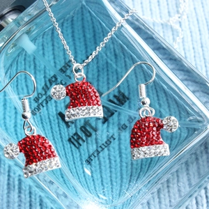 Christmas hat jewelry set with red crystal necklace and earrings on a blue background