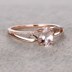 Anello di fidanzamento in oro rosa con gemma rosa ovale e fascia divisa pavé