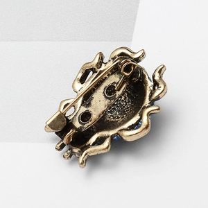 Broche scarabée vintage en alliage de bronze avec strass bleus sur fond blanc épuré