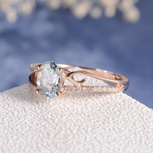 Anello di fidanzamento in oro rosa con gemma blu ovale e fascia con diamanti a vite