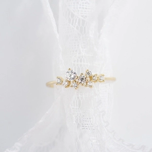 Eleganter 18 Karat vergoldeter Ring mit neun kleinen Diamanten auf weißer Spitze
