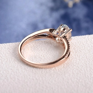Dettaglio macro di anello di fidanzamento oro rosa con zircone ovale e pietre laterali