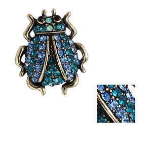 Détails de strass bleus sertis sur une broche scarabée vintage en bronze