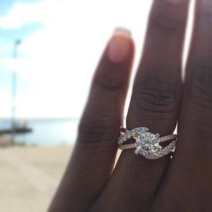 Bague élégante en or rose avec diamants croisés et solitaire porté à la main au bord de mer