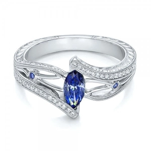 Détail d'une bague de fiançailles avec saphir bleu marquise et pavé de diamants étincelants