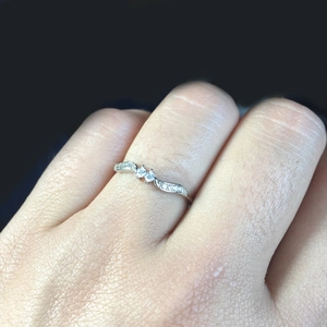 Minimalist leaf-inspired wavy silver ring with micro-pave crystals on female finger