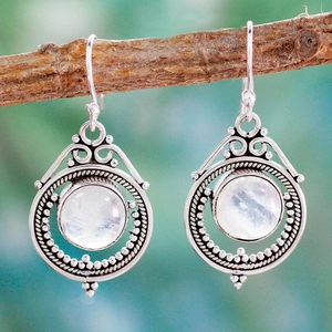 Vintage silver moonstone drop earrings with boho moon design hanging on a branch