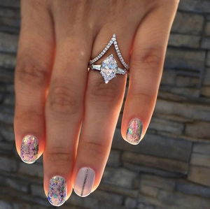 Close-up of marquise-cut zircon wedding set with V-shaped diamond band on hand