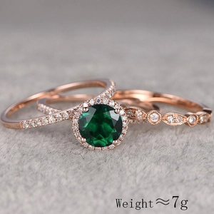 Three-piece rose gold ring set with round emerald stone and vintage halo design