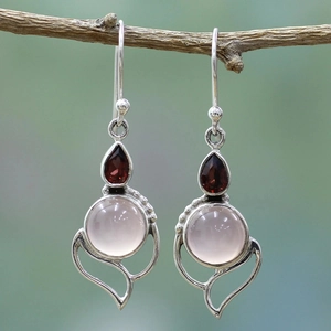 Pendientes de plata con cuarzo rosa y piedra roja en forma de pera sobre una rama