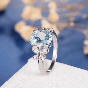Elegant silver butterfly ring with oval light blue topaz and white accent stones