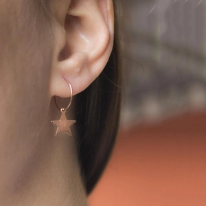 Primer plano de pendientes de estrella en oro rosa para lucir un estilo elegante