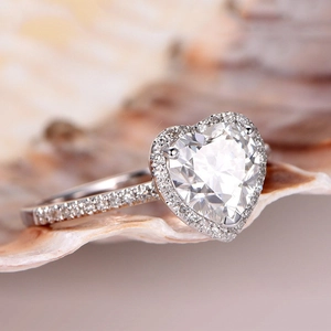 Anello di fidanzamento elegante con cristallo a cuore e diamanti su una conchiglia