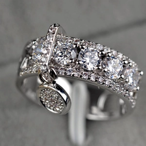 Vista macro de anillo ajustable plateado con circonitas micro-pavé y colgante redondo