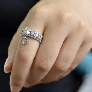 Anillo de banda ancha en acabado plateado con circonitas brillantes y dije redondo