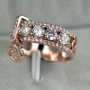 Anillo de oro rosa con circonitas y un colgante con diseño de hebilla de cinturón