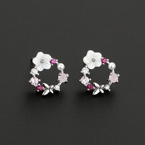 Close-up of floral hoop earrings with shell petals, pearls, and colorful zircon inlay