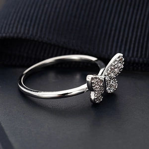 Minimalistischer Schmetterlingsring mit Zirkonia-Mikropavé auf schwarzem Lederhintergrund