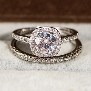 Juego de dos anillos halo plateados con piedra central redonda y bandas de micro-pavé