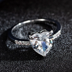 Elegant heart-shaped zircon engagement ring with silver finish on a dark background