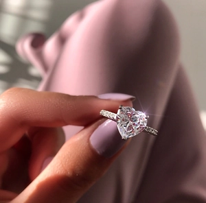 Close-up of heart-cut zircon ring with pavé side stones on silver band