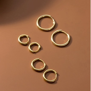 Tres pares de pendientes de aro dorados minimalistas en tamaños pequeño y grande