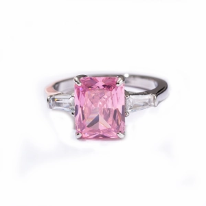 Elegant three-stone ring with radiant cut pink zircon and silver band on white background