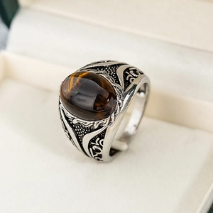 Vista macro di un anello vintage con occhio di tigre e incisioni floreali sulla fascia