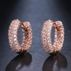 Close-up of rose gold hoop earrings featuring three rows of micro-pave cubic zirconia