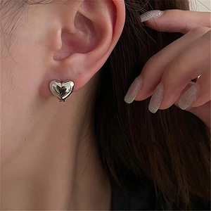 Minimalist 3D heart-shaped silver earrings worn for a sweet and stylish feminine look