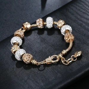 Gold and silver snake chain charm bracelet with heart pendant and sparkling crystals