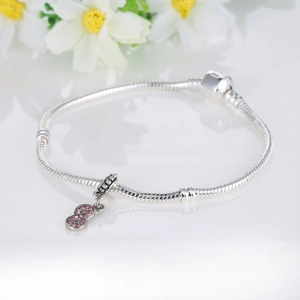 Macro detail of infinity charm on snake chain bracelet with pink pave zircon stones