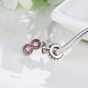 Silver snake chain bracelet featuring an infinity symbol charm paved with pink crystals