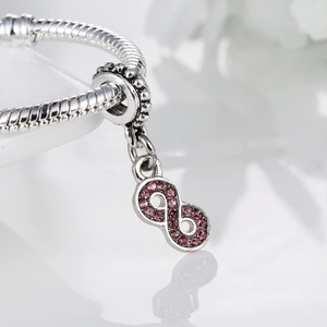 Infinity symbol charm with pink stones on a silver snake chain bracelet