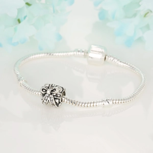 Dettaglio di un bracciale a maglia snake in argento con uno scintillante ciondolo regalo