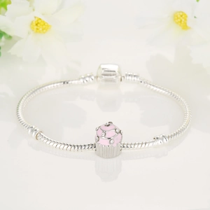 Silver snake chain bracelet with pink enamel cupcake charm and pavé crystals on white background