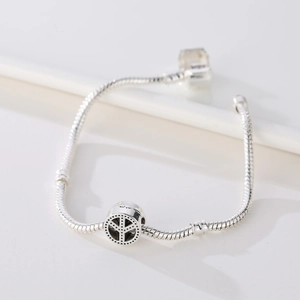 Pulsera de cadena de serpiente plateada con dije de signo de la paz y detalles oxidados
