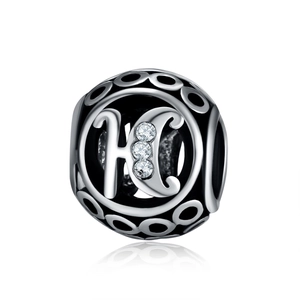 Detailed macro view of 925 silver hollow bead with letter H and zircon stones