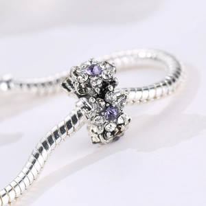 Silver flower charm bracelet with purple and white crystals on a snake chain