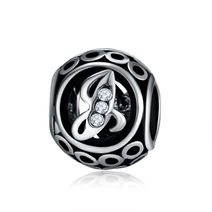 Close-up of ethnic alloy hollow charm bead with letter B and white zircon stones