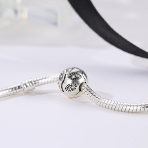 Silver snake chain bracelet with a hollow rhinestone-studded leaf pattern bead charm