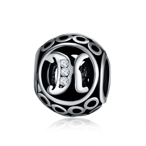 Macro detail of vintage S925 silver charm bead featuring an openwork letter K with crystals