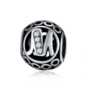 Detailed close-up of hollow alloy bead charm with letter M and zircon stone inlay